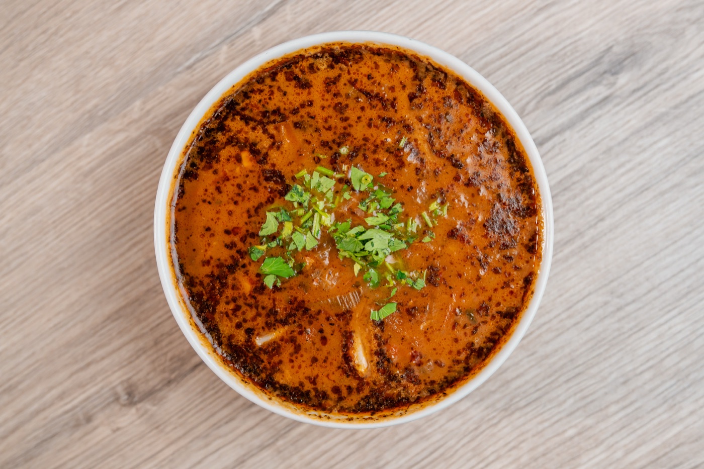 Flaczki z kalmarów po polsku — gęsty wywar pomidorowy z paskami kalmara i natką pietruszki